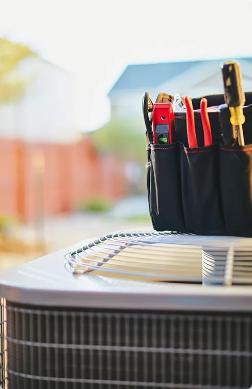 Tool bag on top of an outdoor heating and cooling unit