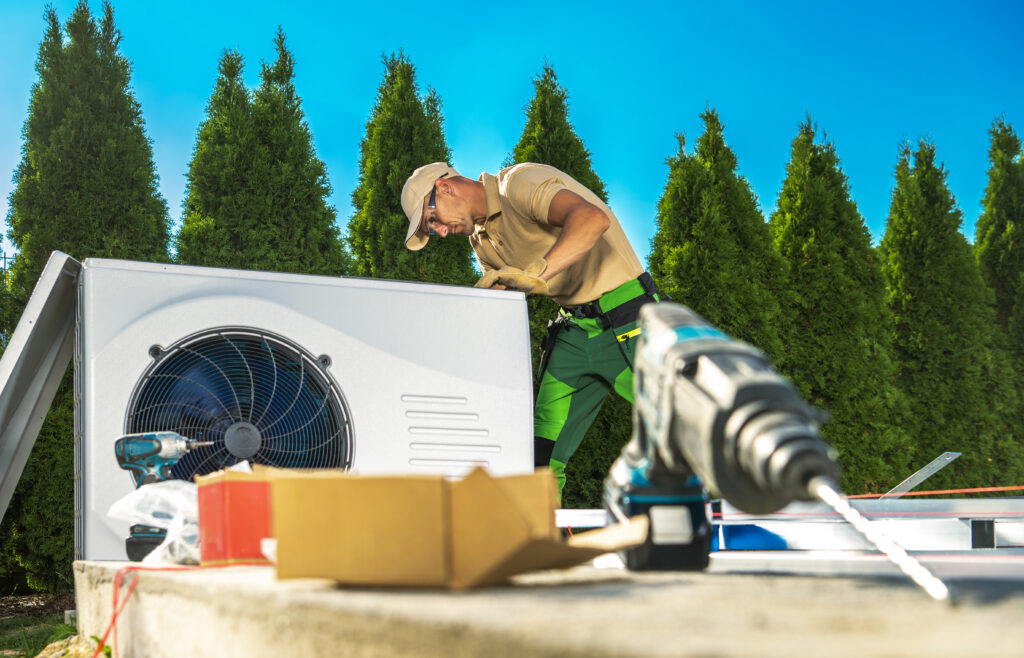 HVAC technician repairing an outdoor air conditioning unit during summer heat to restore cooling and system performance.
