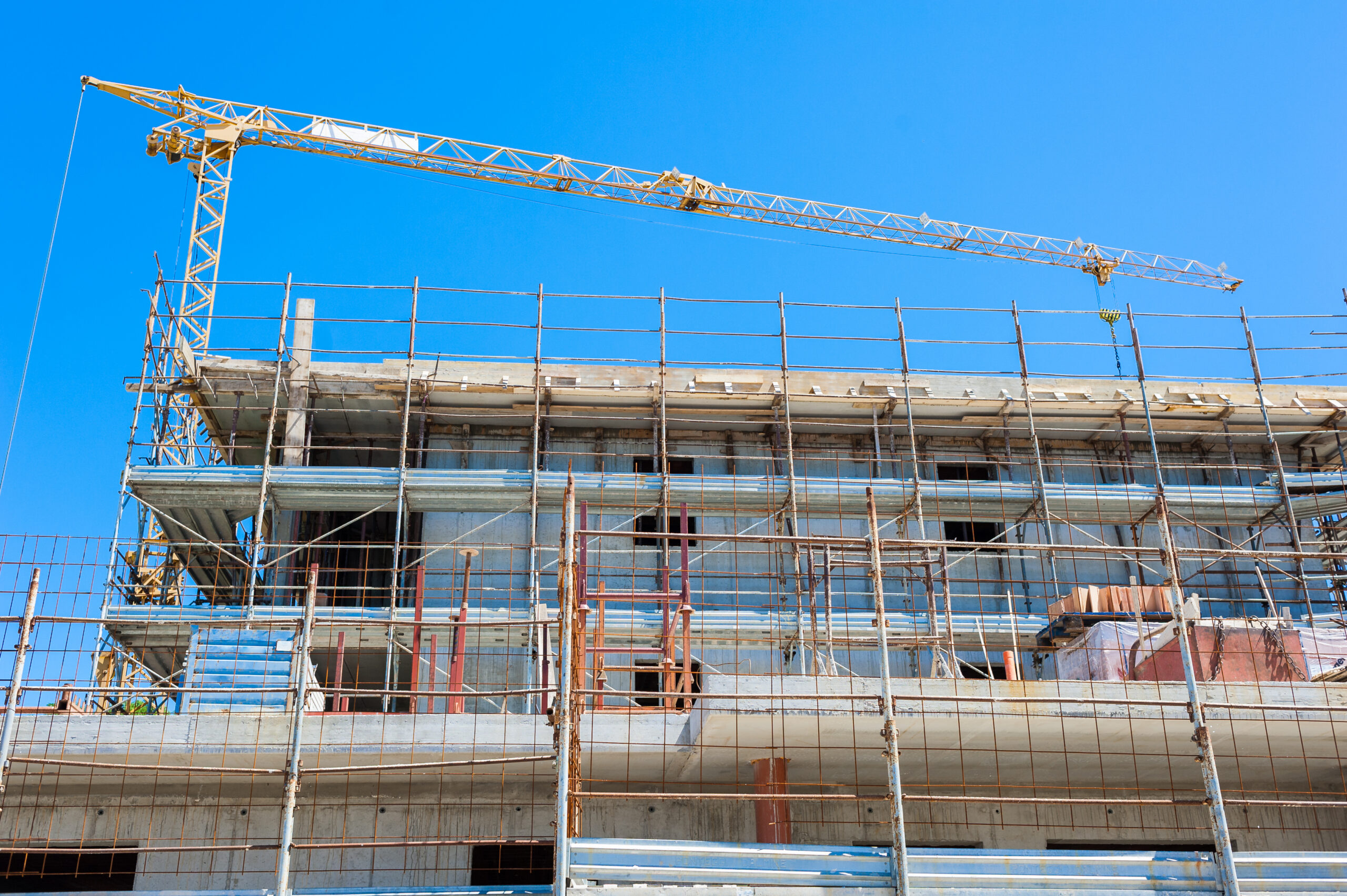 Commercial new construction project with crane and structural framing