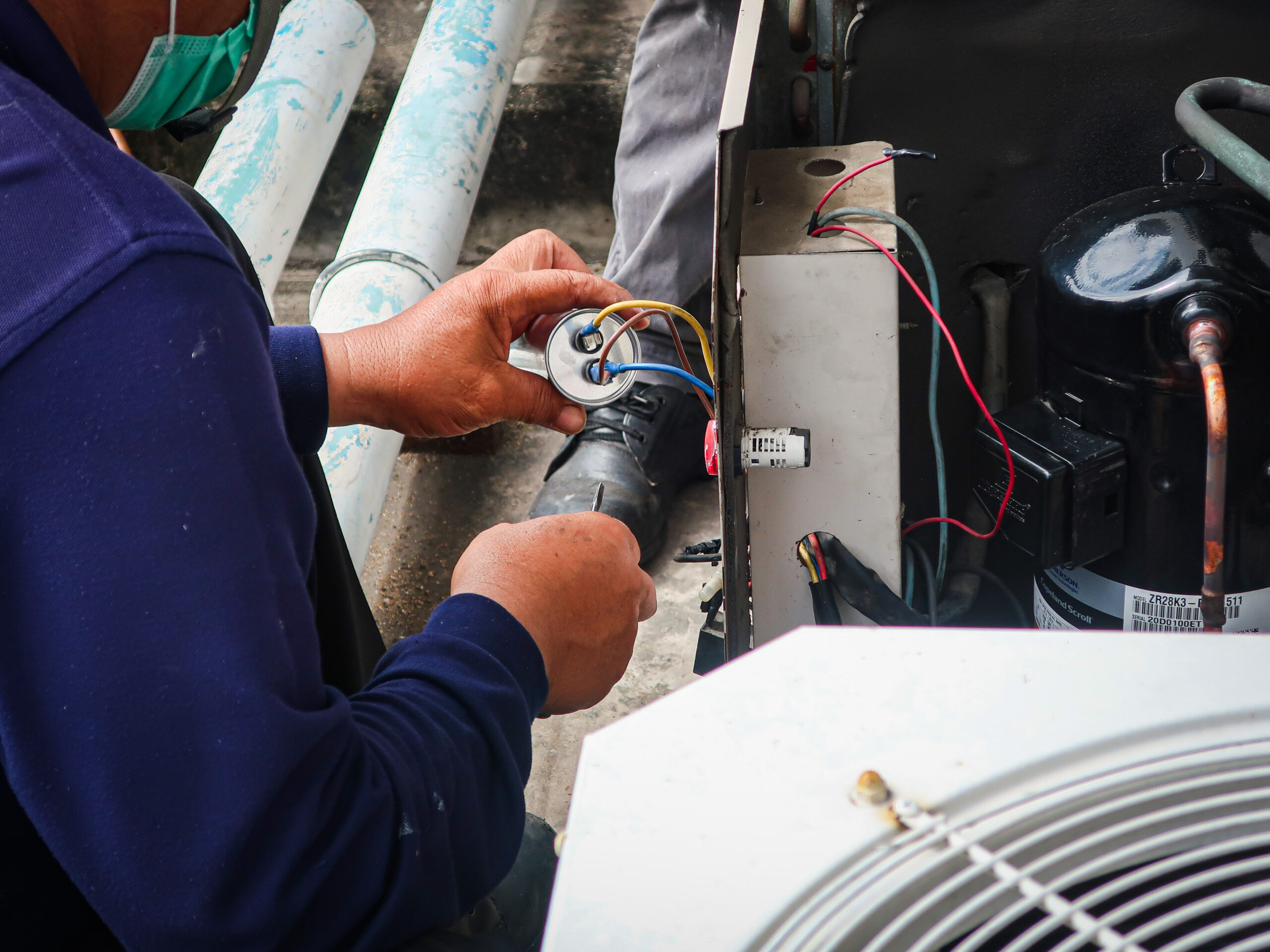 Commercial HVAC technician inspecting and servicing air conditioning equipment
